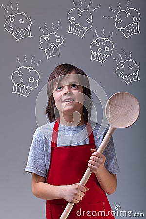 Young chef with apron and large wooden spoon Stock Photo