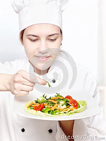 Young chef decorating delicious salad Stock Photo