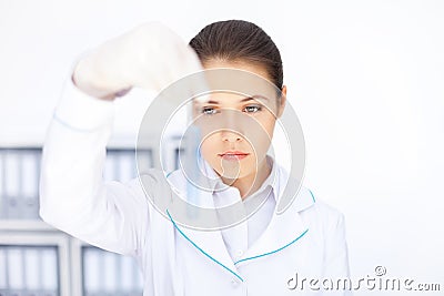 Young chemical female researcher holding glass tube with blue fl Stock Photo