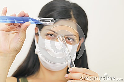 Young chemical female researcher holding two glass tubes Stock Photo