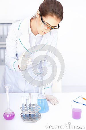 Young chemical female researcher with vials and flasks Stock Photo