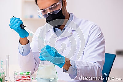 Young male chemist in drug synthesis concept Stock Photo