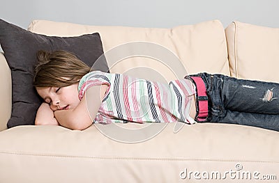 Young Child Asleep on a Leather Sofa Stock Photo