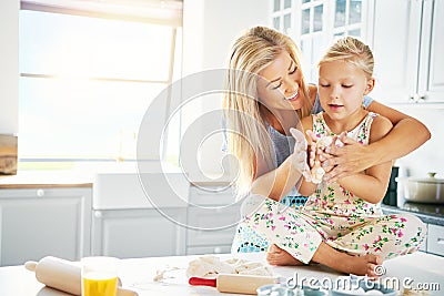 Young child getting help to knead bread dough Stock Photo