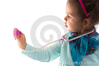 Young child girl with a phonendoscope playing doctor. Healthcare and medicine concept. Stock Photo