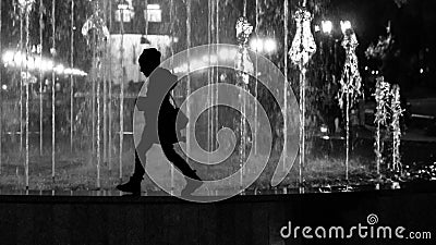 Young child girl walking the fountain border. Stylized as black and white silhouette Stock Photo