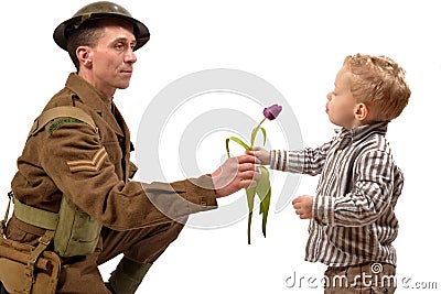 A young child gives a flower to a British soldier Stock Photo