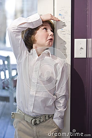 Young child measuring height on growth chart Stock Photo
