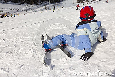 Young Child rests on the edge of a ski slope Stock Photo