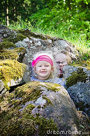 Young children, the boy with girl hid among the rocks Stock Photo