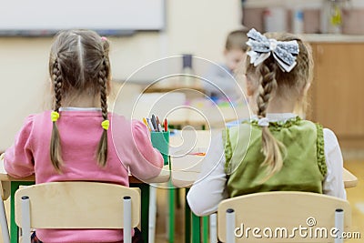 Young children sit in kindergarten at the table engaged, draw, learn in the nursery Editorial Stock Photo