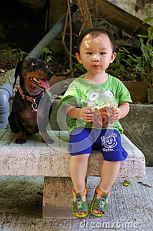 Young Chinese boy on street eating Editorial Stock Photo