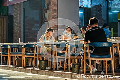 Young chinese people eating in a street in late afternoon Editorial Stock Photo