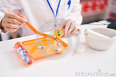 Young chinese woman pharmacist organizing pills dose at atelier Stock Photo