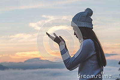 Young christian woman hands open palm up worship and praying to god at sunrise, Christian Religion concept background Stock Photo