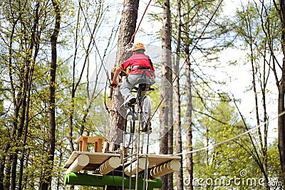 Young climber on a special bike rides on tightrope Stock Photo