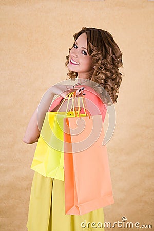 Young colorful dressed woman with color shopping bag Stock Photo