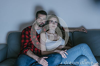 , concentrated couple watching tv on sofa Stock Photo
