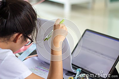 Young concentrated woman reading text book using tablet research internet online data for school exam. Asian girl student study Stock Photo