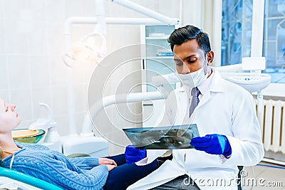 Young confident asian male dentist checking teeth x ray of patient. Dental clinic concept. Stock Photo