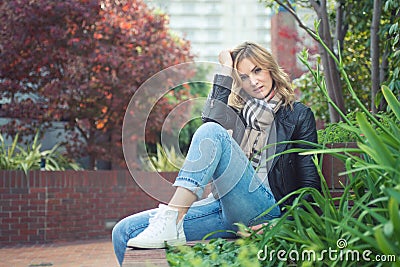 Young confident attractive woman sitting ouside Stock Photo