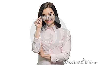 Young confident business woman looking into the camera with lowered glasses on a white isolated background Stock Photo