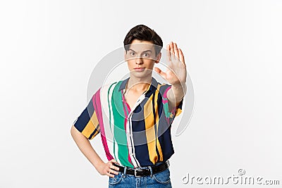 Young confident gay man saying no, showing stop sign and looking displeased, standing over white background Stock Photo