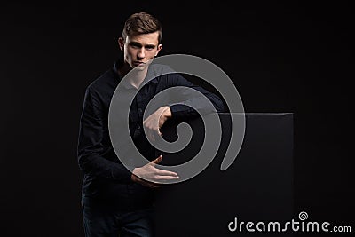 Young confident man showing presentation, pointing on placard Stock Photo