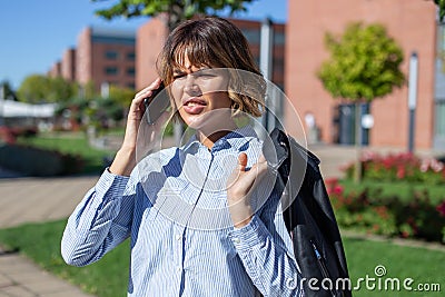 Young confused businesswoman in park calling by phone Stock Photo