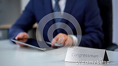 Young congressman using tablet pc, reading political news online, election Stock Photo