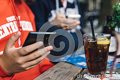 Young connected with a phone and drinking a coke. Stock Photo