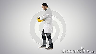 Young construction engineering student walking and putting cap o Stock Photo