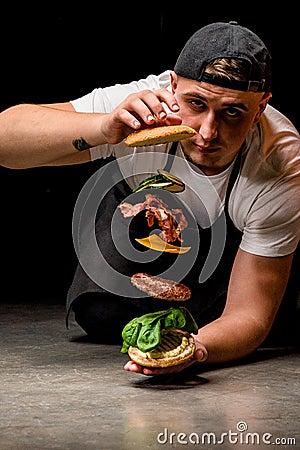 Burger ingredients levitating, dark background and fire Stock Photo