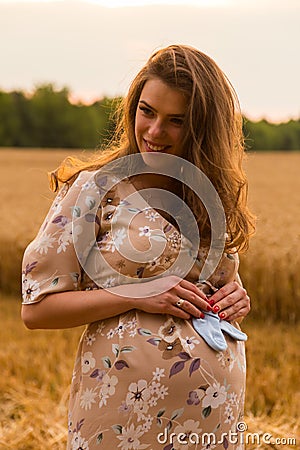 Young couple awaiting baby embrace the field Stock Photo