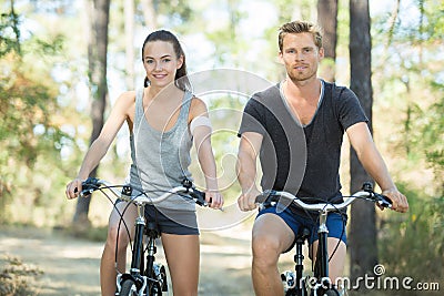 Young couple with bicycle in forest Stock Photo