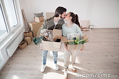 Young couple with boxes kissing when moving in new flat, new home and relocation concept. Stock Photo