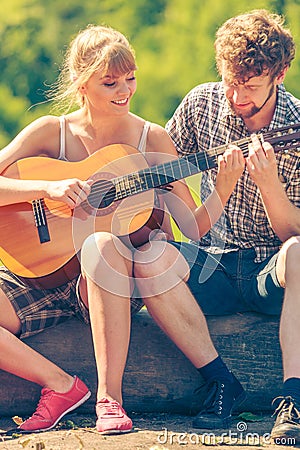 Young couple camping playing guitar outdoor Stock Photo