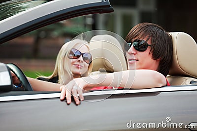 Happy young fashion couple driving a car Stock Photo