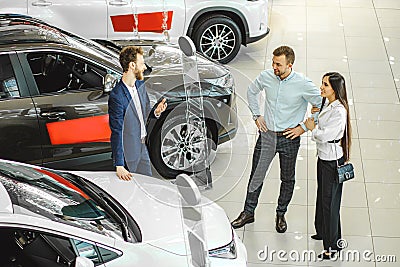 Young couple choosing new car in showroom. service, selling Stock Photo