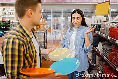 Young couple choosing plates in houseware store Stock Photo