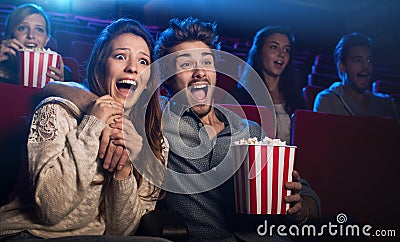 young couple cinema watching horror movie scared screaming holding her boyfriend s hand 61549359