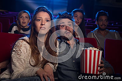 Young couple at the cinema watching an horror movie Stock Photo