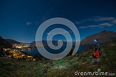 Night scene of young couple view queenstown, new zealand. Stock Photo