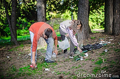 Young couple collect garbage thrown in nature park Stock Photo