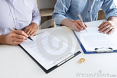 Young couple in the courthouse filing pen to signing divorce papers or premarital agreement, deciding on marriage divorce concept Stock Photo