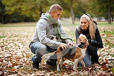 Young couple with dog in autumn park Stock Photo