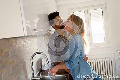 Young couple doing dishes in the kitchen and smiling Stock Photo