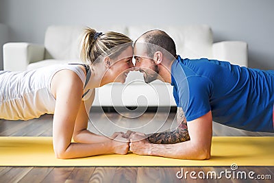 Young couple doing exercise at home in living room. Stock Photo