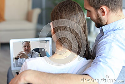 Young couple doing video conference with doctor on laptop. Online consultation Stock Photo