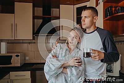 Young couple drinking coffee in kitchen at home in the morning. Young happy couple, newlyweds family start new day and Stock Photo